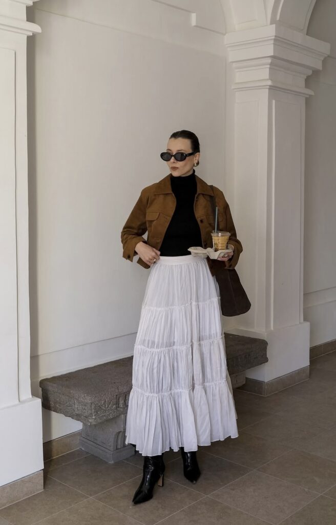 white maxi skirt with a tucked in turtleneck and brown jacket with ankle boots
